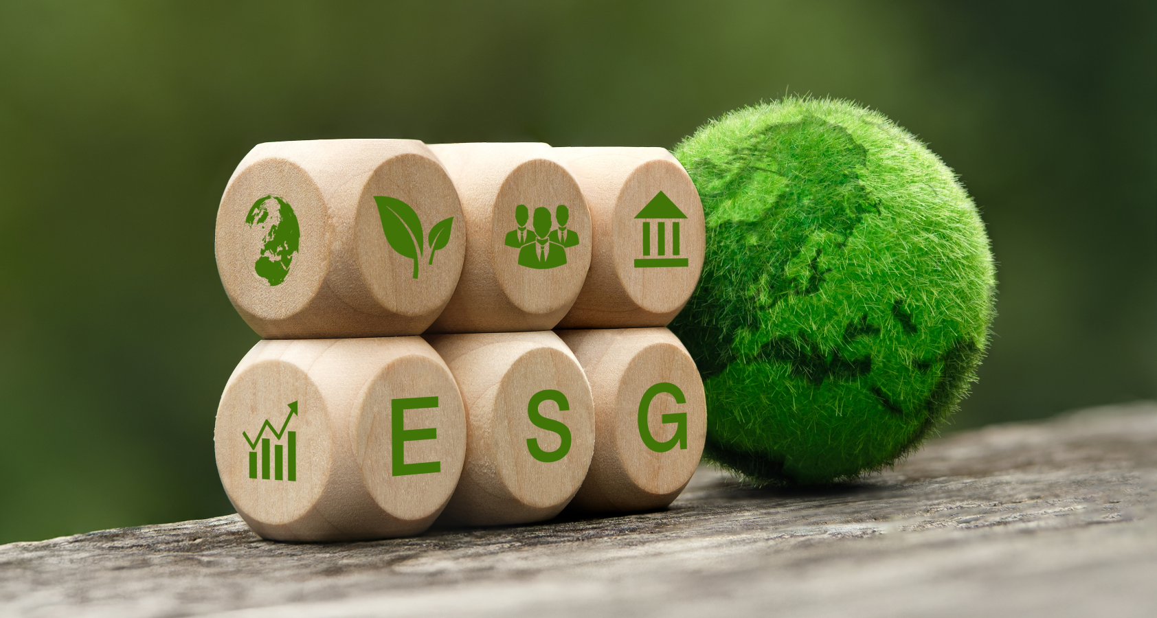 木製ブロックに「ESG」と関連アイコンが描かれ、隣に緑色の地球を模したボールが置かれている